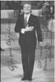  Fotografia del comico in forma di cartolina e sua dedica autografa senza data anni 60 
